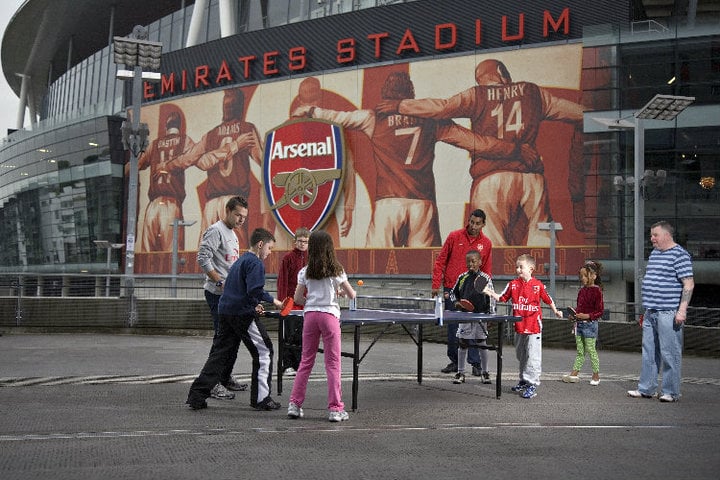 kids playing table tennis in front of the Emirates Stadium, London